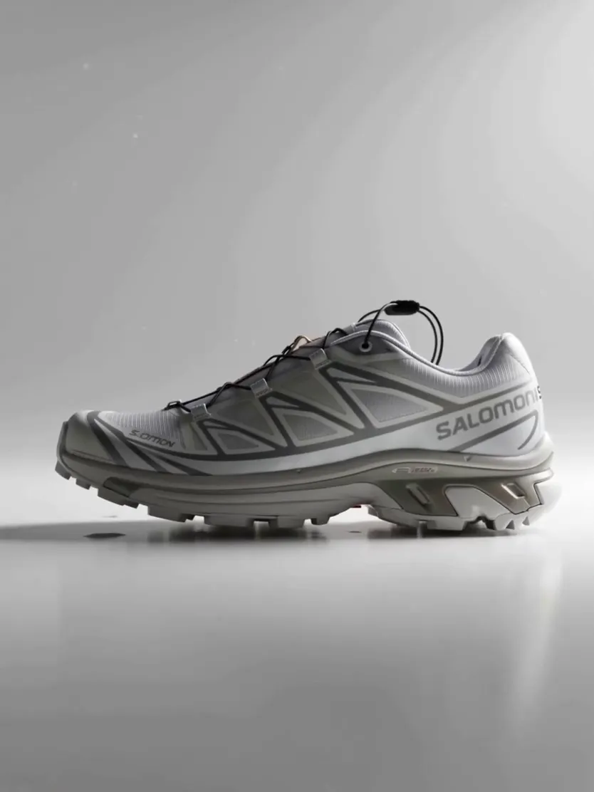 A clean studio photo of a grey trail running shoe